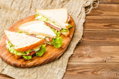 Salata ve sosisli taze burger mutfakta branda kumaş üzerinde.