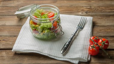 Ahşap masada keten peçete üzerinde nefis vejetaryen yemeği.