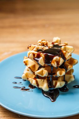 Mavi tabakta çikolatalı ev yapımı waffle.
