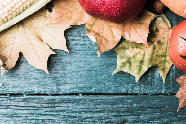 Izolovaný Obrázek Rajčete Granátové Jablko Podzimní Listy Modrém Dřevěném Pozadí — Stock fotografie