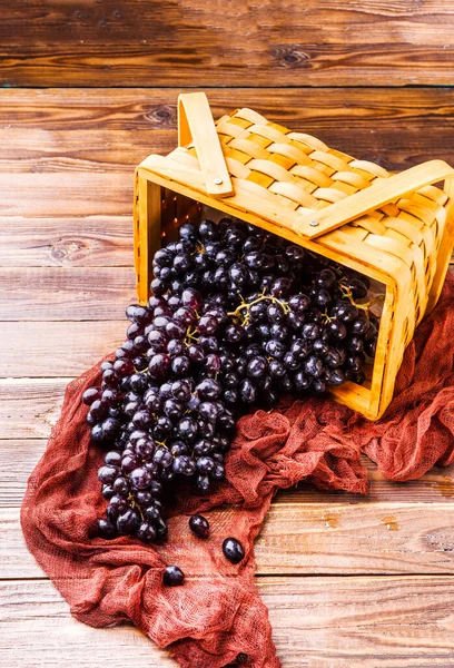 Foto Schwarzer Trauben Holzkorb Mit Weinrotem Tuch Auf Dem Tisch — Stockfoto