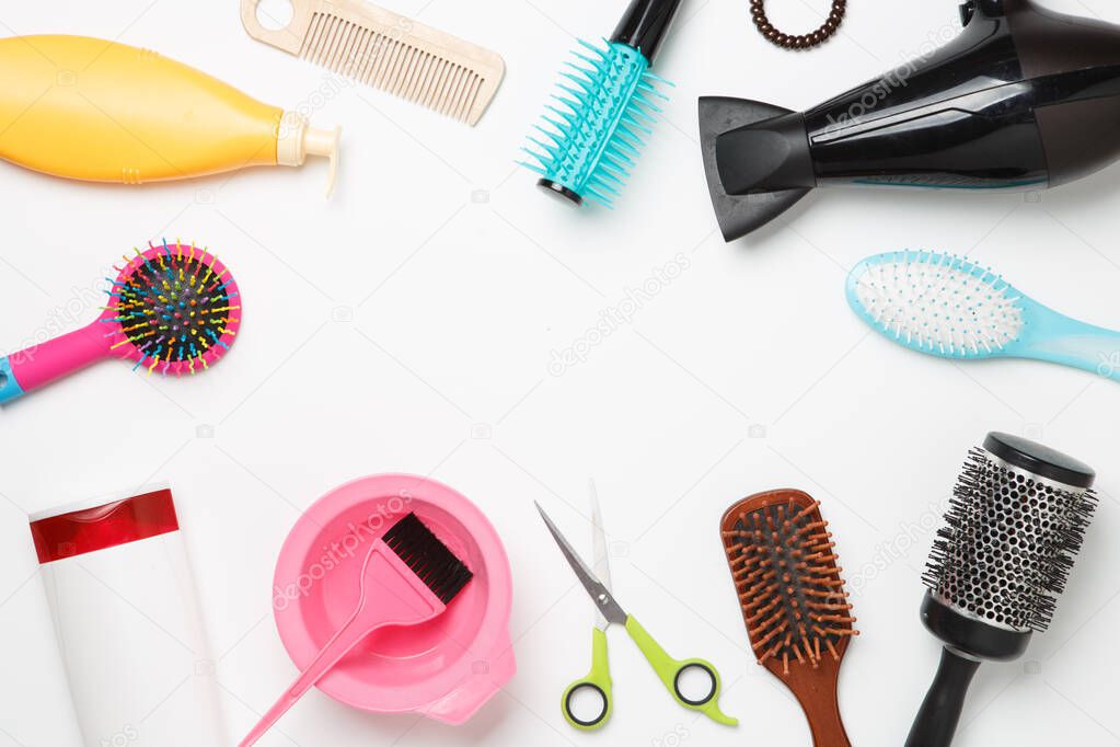 Photo of accessories hairdresser, hair dryer, combs located in circle on clean white background. Empty space for text