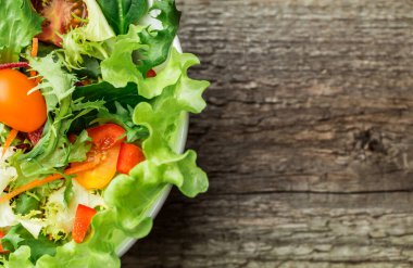 Taze sebze - domates, havuç, biber ve karışık yeşillik - roka salata, mesclun mache - ahşap arka plan üzerinde.