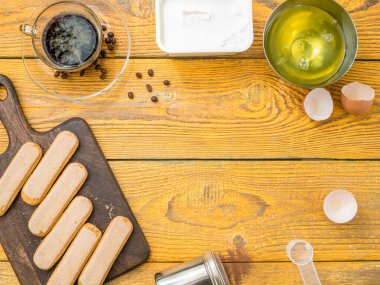 Masanın üstünde Savoyardi kurabiyeleri, kahve, krem peynir. Metin için yer