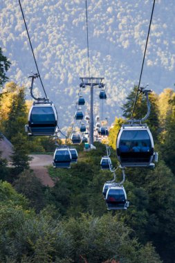 Gün içinde dağ alanındaki teleferik kulübelerinin fotoğrafı.