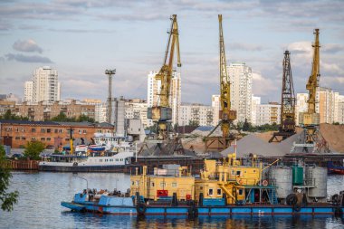 Loading and unloading of sand by crane. The shore of the river Moscow clipart