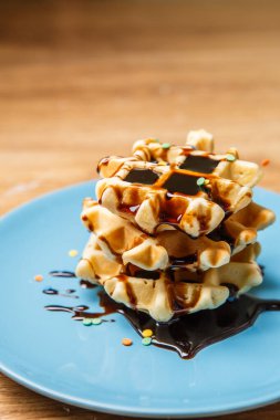 Mavi tabakta çikolatalı ev yapımı waffle.