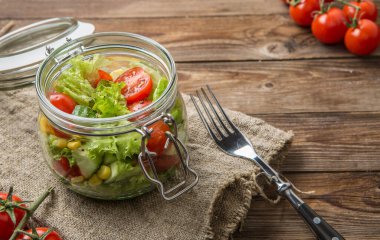 Sebze salatası, keten peçete, çatal ve kiraz domatesli hayat.