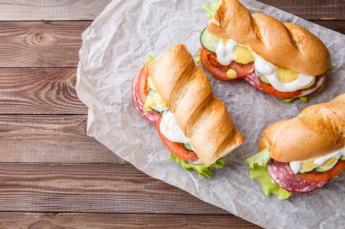 Tahta masada sosisli ve sebzeli taze sandviçler.