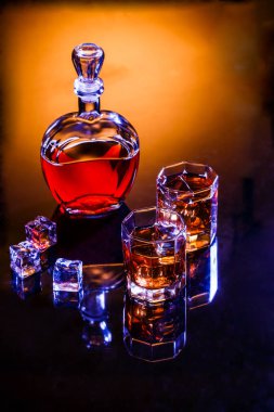 Dekan ve gri arka planda buzlu viski ve iki bardak, stüdyoda fotoğraf.