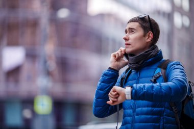 Telefonda konuşan ve şehirde akıllı adam arayan bir adam.