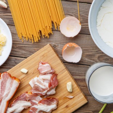 Ahşap masada makarna malzemelerinin fotoğrafı.