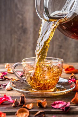 Kahverengi arka planda cam bardakta siyah çay.