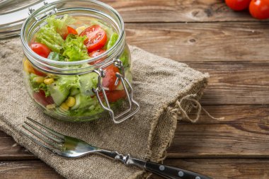 Tahta masada taze sebzeler, çatal, peçete, kiraz domatesli kahvaltı.