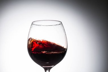 Bir kadehe şarap akıntısı dökülüyor. Yakın çekim şarap serpintisi.