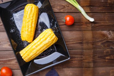 Tahta masadaki siyah tabakta mısır. Helthy yemeği..