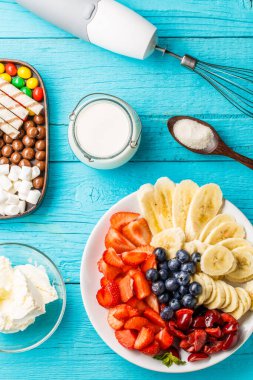 Mavi masadaki meyveli milkshake 'ler için malzemeler