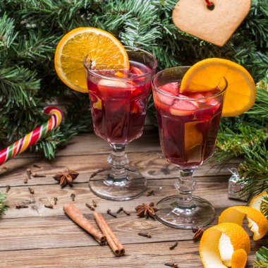 Portakallı, elmalı ve baharatlı iki bardak sıcak şarap. Noel arkaplanı.
