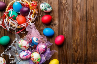 Süslü Paskalya yumurtalarının ahşap masadaki kurdeleli fotoğrafları.