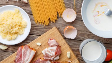 Ahşap masadaki makarna malzemelerinin fotoğrafı.