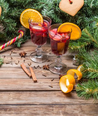 Portakallı, elmalı ve baharatlı iki bardak sıcak şarap. Noel arkaplanı.