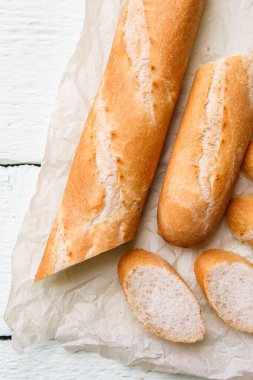 Beyaz ahşap masada kağıt üzerinde esintili uzun somun.