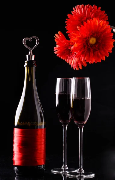 Red Flowers Bottle Wine Glasses Black Background — Stock Photo, Image