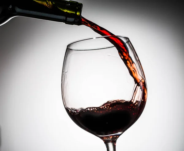 空の背景にガラスからワイングラスにボトルから注がれたブドウワイン — ストック写真