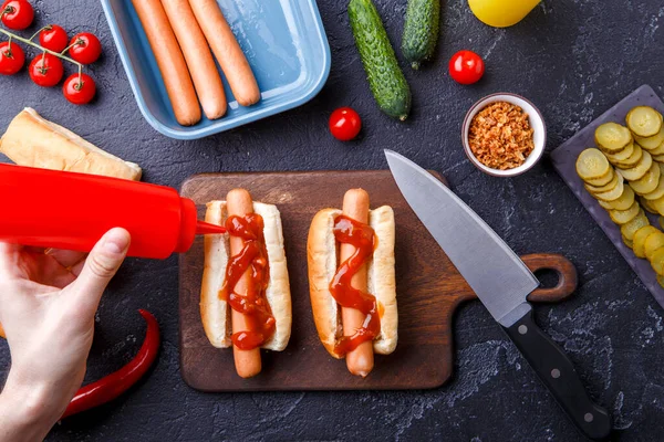Zdjęcie Szczycie Stołu Składnikami Hot Dogów Deska Krojenia Męskie Dłonie — Zdjęcie stockowe