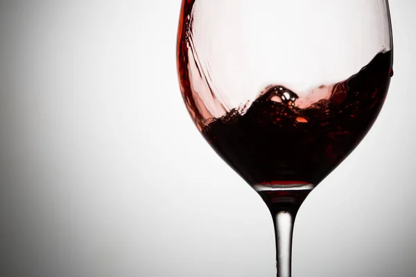 赤ワインの波がワイングラスの壁の近くを流れています 動き出す — ストック写真