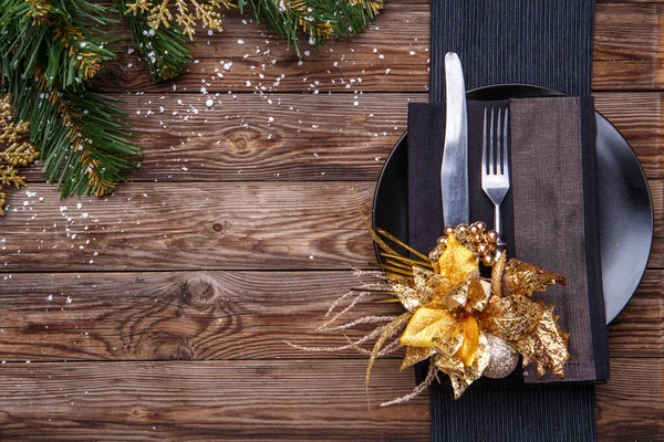 圣诞餐桌摆设用黑色餐巾 叉子和刀 装饰金花和圣诞松树枝条 圣诞节背景 — 图库照片