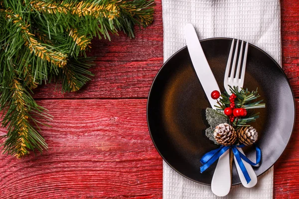 圣诞餐桌的照片 餐盘上有叉子和小刀 还有云杉树枝 — 图库照片