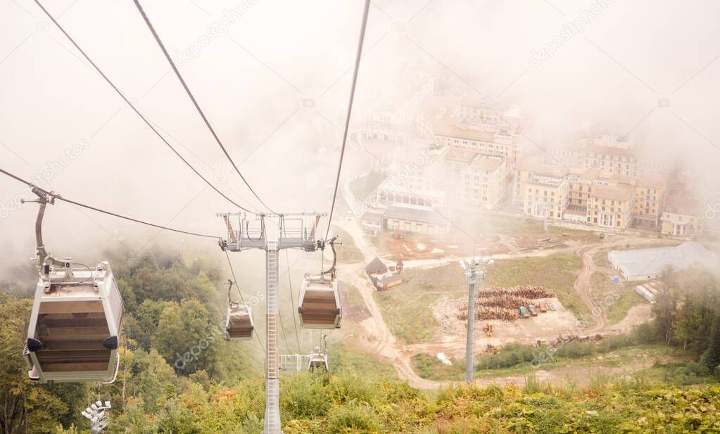 Picture of funicular in mountains against background of misty sky during day