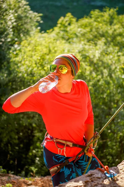 Foto Van Een Vrouw Klimmer Zonnebril Drinkwater Zitten Naast Berg — Stockfoto