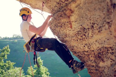Kaya tırmanışçısının yaz aylarında dağlara tırmanışının resmi.