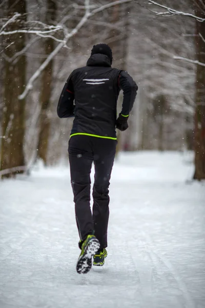 Zdjęcie Tyłu Biegającego Sportowca Wśród Drzew Zimowym Lesie Rano — Zdjęcie stockowe
