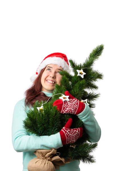 照片上的女人戴着圣诞老人的帽子 手上拿着圣诞树 白色的背景是空的 — 图库照片