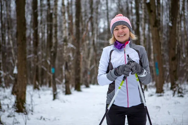 Imagem de mulher sorridente com esquis na floresta de inverno — Fotografia de Stock