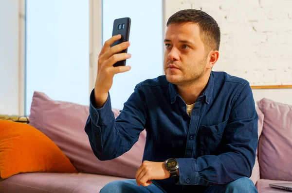 Homme Assoit Sur Canapé Utilise Son Smartphone Concept Médias Sociaux — Photo