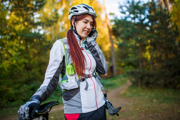 Wizerunek Dziewczyny Sportowej Kasku Rowerowym Rozmawiającej Przez Telefon Jesiennym Lesie — Zdjęcie stockowe