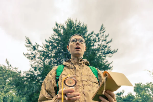 Kép Alulról Meglepett Ember Iránytűvel Jegyzettömbbel Őszi Erdőben Nappal — Stock Fotó