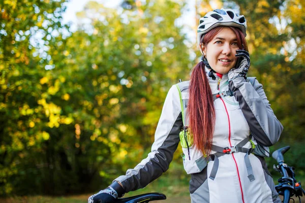 Obraz Sportowej Kobiety Kasku Rowerowym Rozmawiającej Przez Telefon Jesiennym Lesie — Zdjęcie stockowe