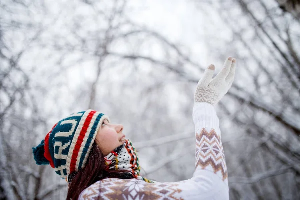 照片上的女孩 头戴针织帽子 白天在森林里打雪仗 背景分散 — 图库照片