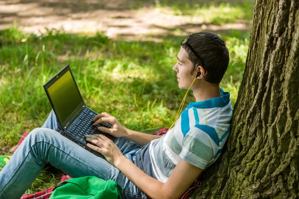 Photo d'un étudiant avec un ordinateur portable et un casque — Photo