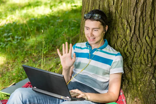 Photo d'un gars avec un ordinateur portable et dans un casque — Photo