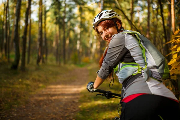 Zdjęcie Uśmiechniętej Kobiety Kasku Sportowej Odzieży Rowerze Jesiennym Lesie — Zdjęcie stockowe