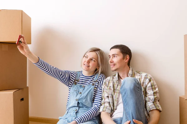 Foto Jovem Casal Fazendo Selfie Sentado Chão Entre Caixas Papelão — Fotografia de Stock