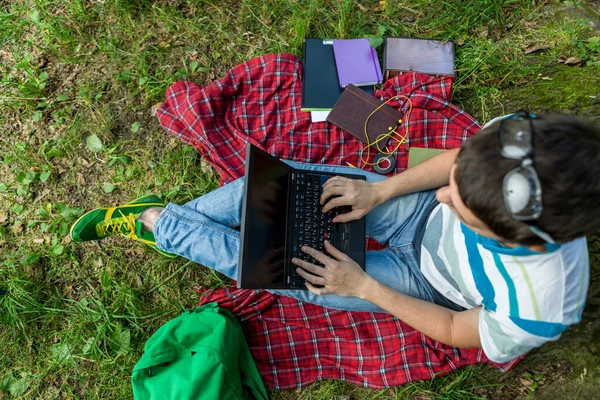 Photo d'un étudiant de haut niveau avec ordinateur portable sur plaid rouge — Photo