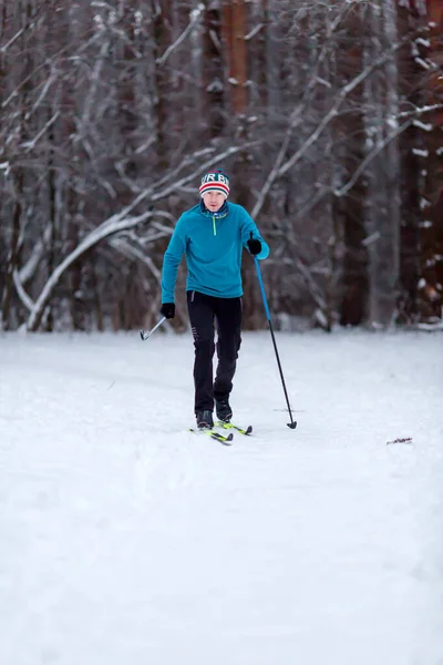 男子滑雪者白天穿着蓝色夹克在冬季森林里的照片 — 图库照片