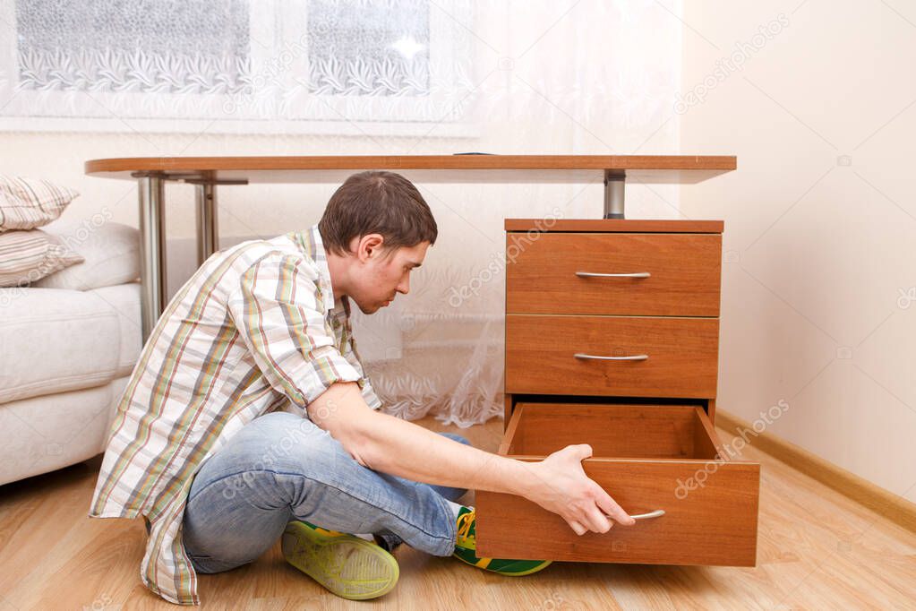 Photo of man picking curb at table in room